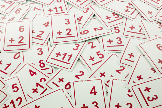 Education: Red addition math cards  randomly spread out on table. Educational school supplies.
Edicational background