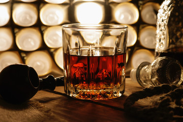 Glass of whiskey, tobacco pipe and rope 