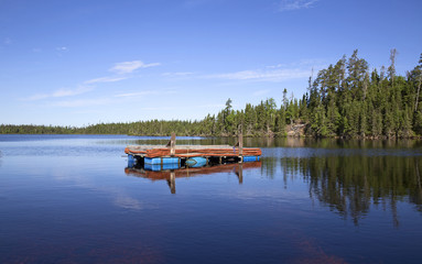 Old floating pier on a calm lake