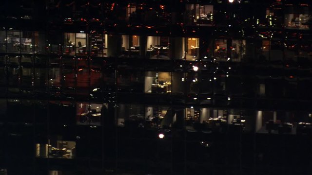 Flight past lighted windows of high-rise at night