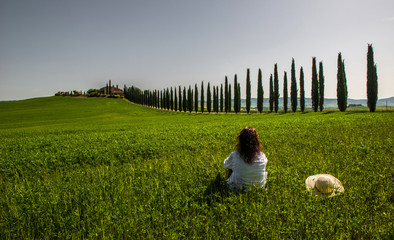 Woman is relaxing watching a tuscan countryside