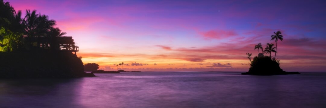 Panoramic silhouette of tropical island with colourful sunrise seascape