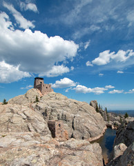 Harney Peak Fire Lookout Tower and pump house with small dam under summer blue sky in Custer State Park in the Black Hills of South Dakota USA