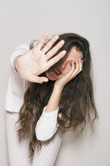 Naklejka premium Portrait of shy smiling girl covering her face with palm of hand
