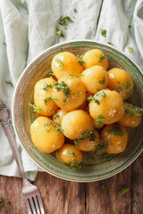 Homemade caramelized new potatoes close-up on a plate. vertical top view 
