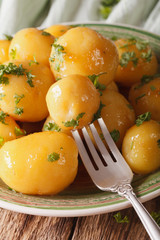 caramelized new potatoes with herbs close-up on a plate. Vertical
