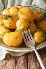 Danish cuisine: glazing new potatoes with parsley close-up. vertical
