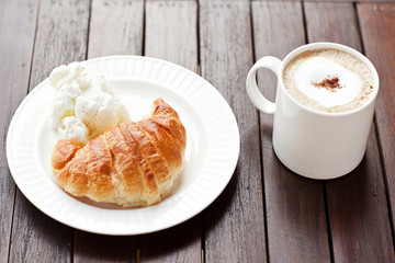 Fresh baked croissants with smug of cappuccino