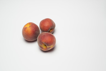 Three peaches on a white background