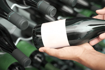 Wine taster showing wine bottles with copyspace