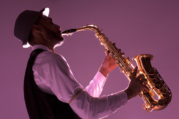Fototapeta na wymiar Silueta de saxofonista sobre fondo magenta