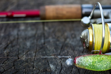 Fishing lure, rod and reel on wood