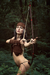 Beautiful huntress aiming with bow