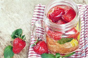 Detox Infused water with lemon, strawberry and mint on wooden background 