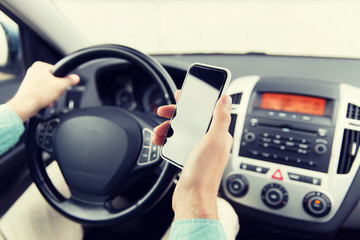 close up of man hand with smartphone driving car