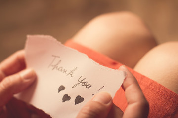 Woman holding a thank you note in her hand