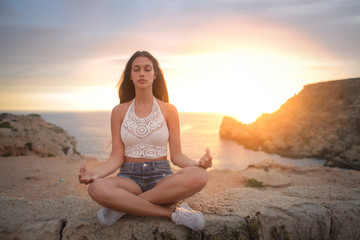 Fototapeta na wymiar Girl doing meditation at the seaside