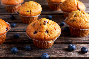 Homemade Blueberry Muffins with fresh berries on wooden table.