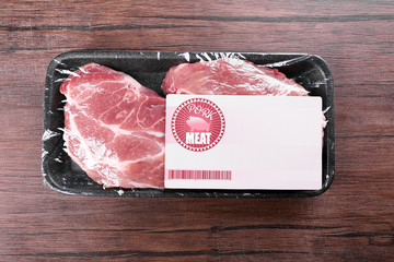 Packed pieces of pork meat on wooden background