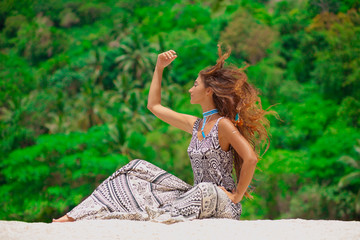 stylish girl sitting on stone rock