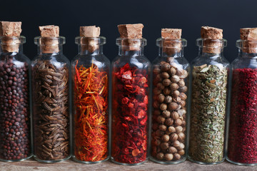 Different spices in small glass bottles, close-up