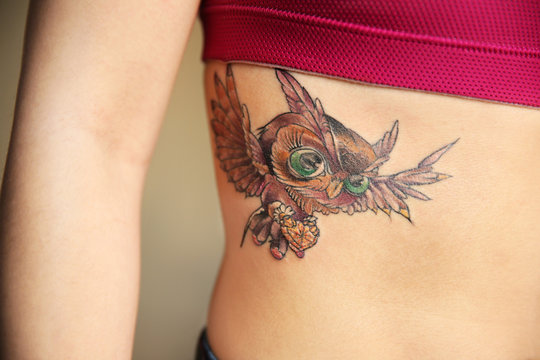 Naklejki Tattoo owl on woman ribs