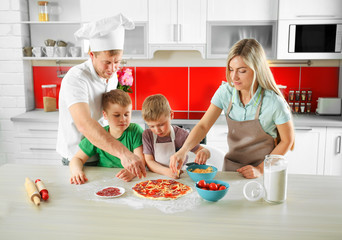 Happy family making pizza in kitchen