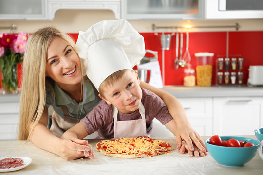 Happy family making pizza in kitchen