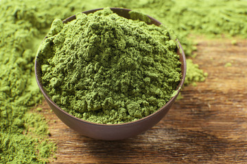 Powdered matcha green tea on wooden table