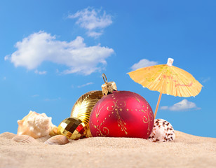 Fototapeta na wymiar Christmas decorations and seashells on a beach sand