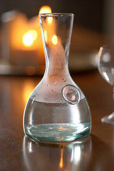 Jug of water on a table lit with warm lights from behind