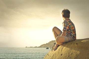 Teenager admiring the horizon at the seaside