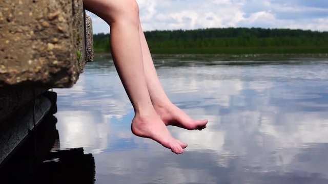 Relaxed legs sways over water