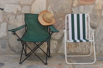 Deck chair and straw hat in the stone house  © cansu