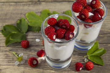 berries and leaves of wild strawberry on background of old wooden planks