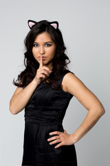 Beautiful make-up woman showing silence sign the finger near lips on isolated light background