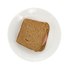 Mortadella sandwich on wheat bread upon a plate isolated on a white background.