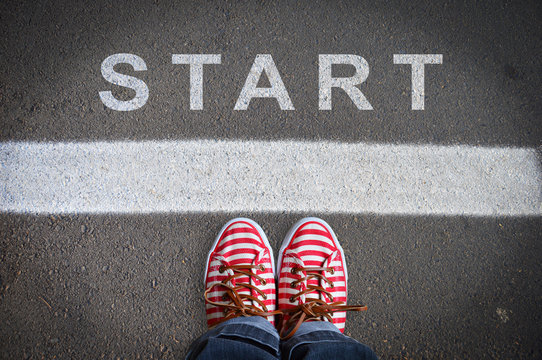 person with sneakers standing in front of the start message
