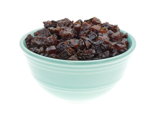 Diced prunes in a bowl on a white background.