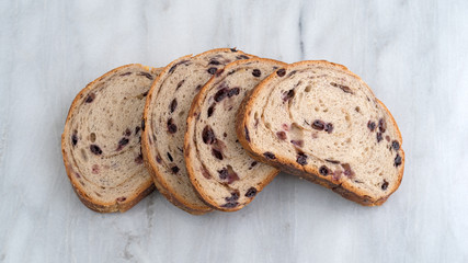 Slices of blueberry streusel bread on a marble cutting board.