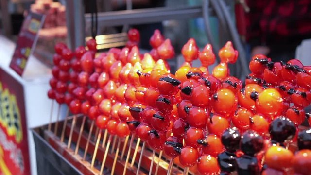 Caramelised tomatoes, Sugar glazed fruits and vegetable selling on stick in Taipei. Taiwan Shilin night market