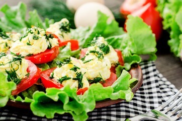 snacks , fresh tomatoes stuffed with eggs, melted cheese , mayonnaise and garlic with dill and lettuce on a wooden background
