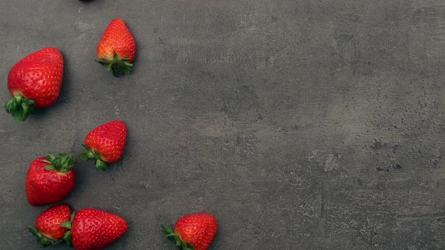 Falling strawberries. Top view on gray kitchen table. Stop motion animation.