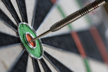 Single dart hitting bull's eye on the dartboard