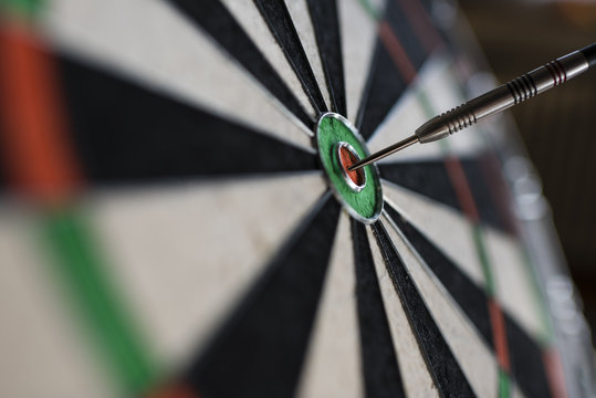 Single dart hitting bull's eye on the dartboard