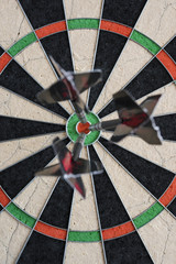 Darts hitting bull's eye on the dartboard