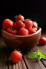 Strawberries in a bowl on black background