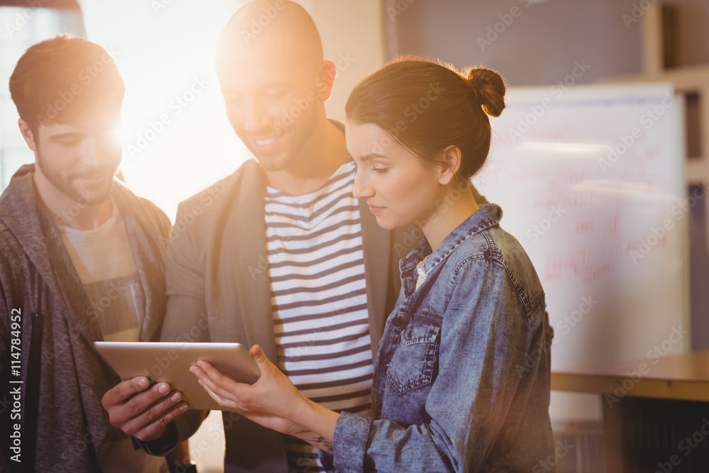 Poster graphic designer using digital tablet with his coworker