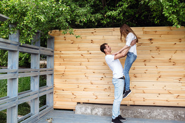 Fototapeta na wymiar couple posing on a background of the wooden wall