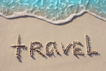 Fototapeta na wymiar Travel Word Handwritten on Sandy Beach